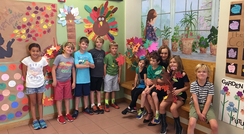 students pose with fall crafts