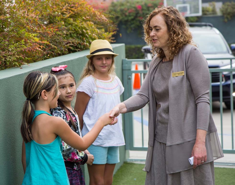 Laura shakes hands with students