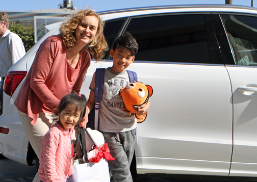 students in front of a car