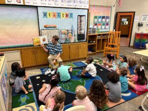 Teacher reading a book to Kindergarten students