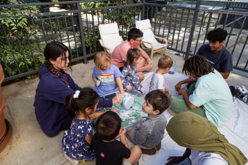 A group of multi-age students sitting in a circle casually chatting.